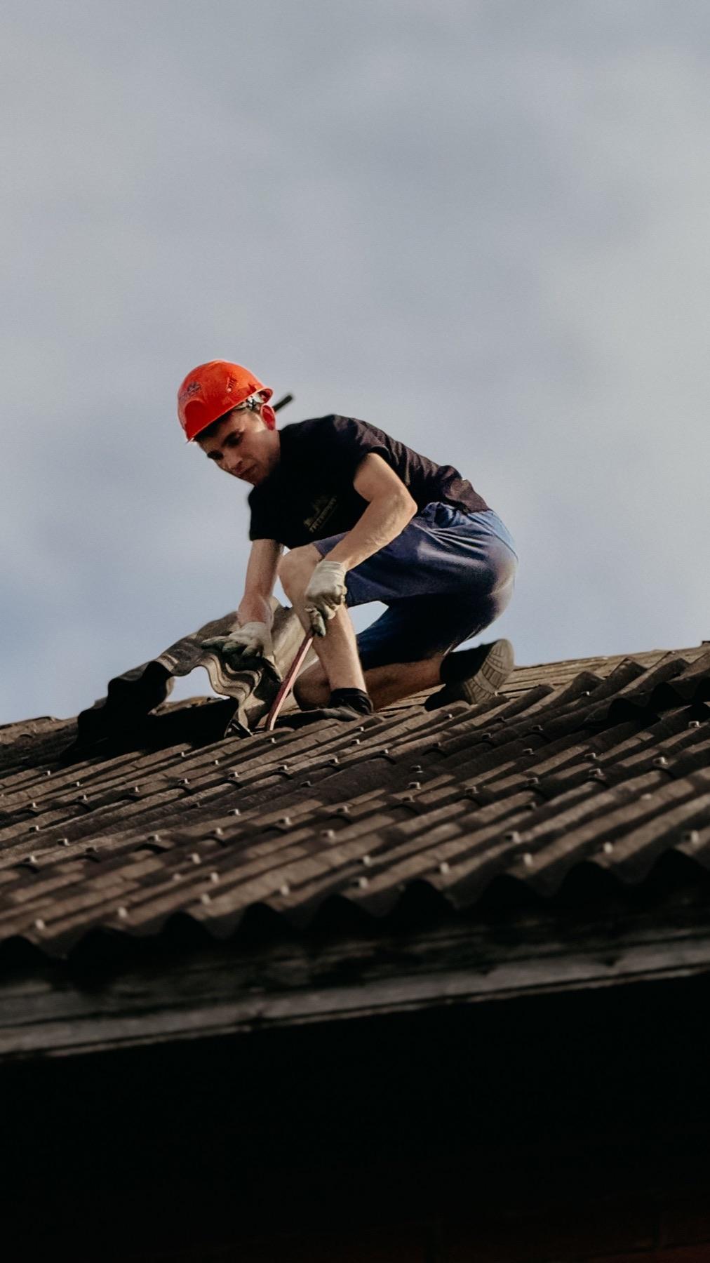 Dakdekker bezig met werkzaamheden op een hellend dak